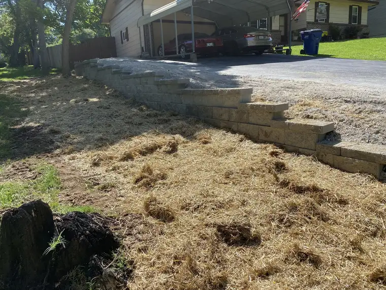 Block wall along a driveway, with the slope behind it graded, Ozark, MO