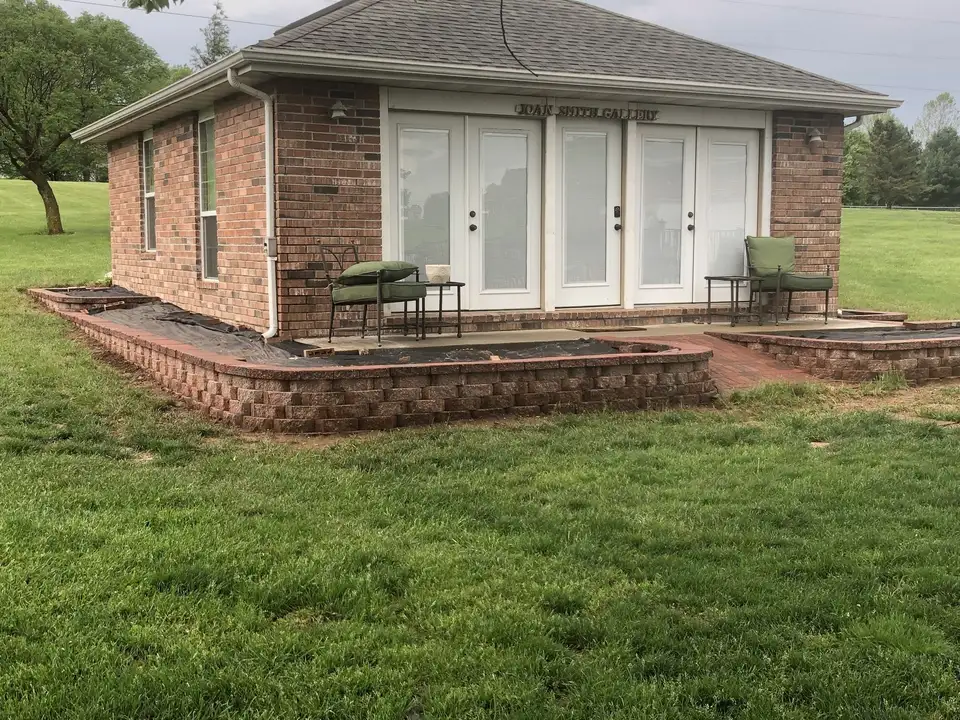 A brick patio and brick planters around a house