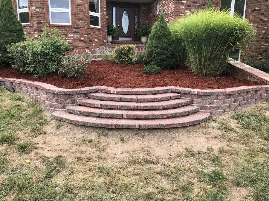 Curved brick wall with steps up to the front walk
