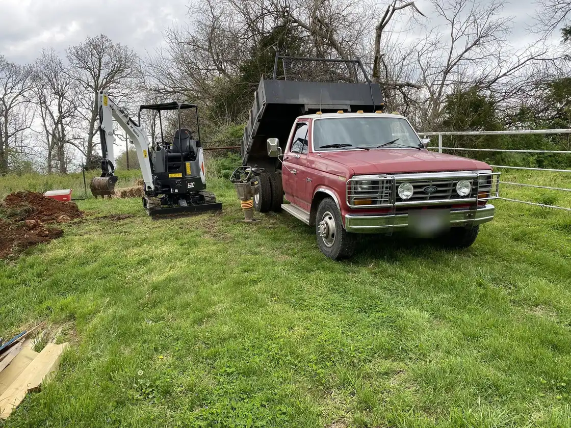 Mini excavator and dump truck on a grading job, one of our jobs