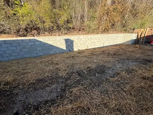 Block wall with the ground in front graded and strawed