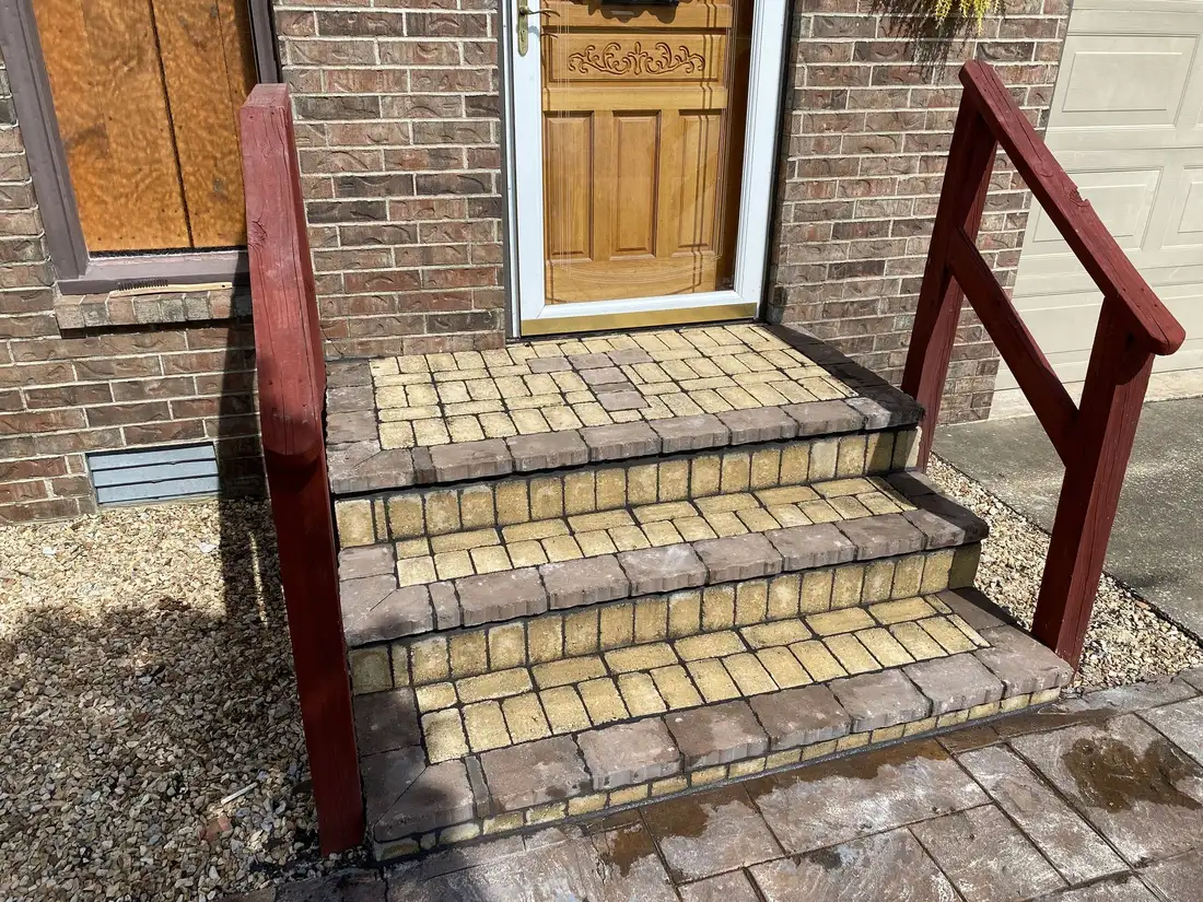 Paver steps with a railing at a front door