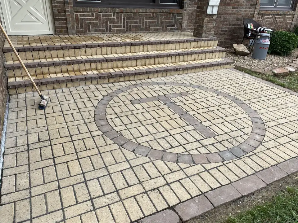 Paver patio with a circle inlay and steps, one of our jobs